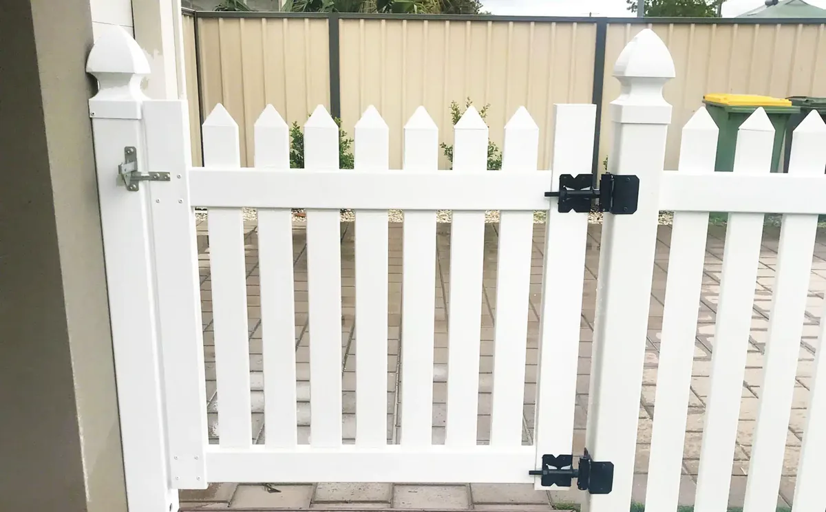 White PVC pedestrian picket gate with black hinges and latch